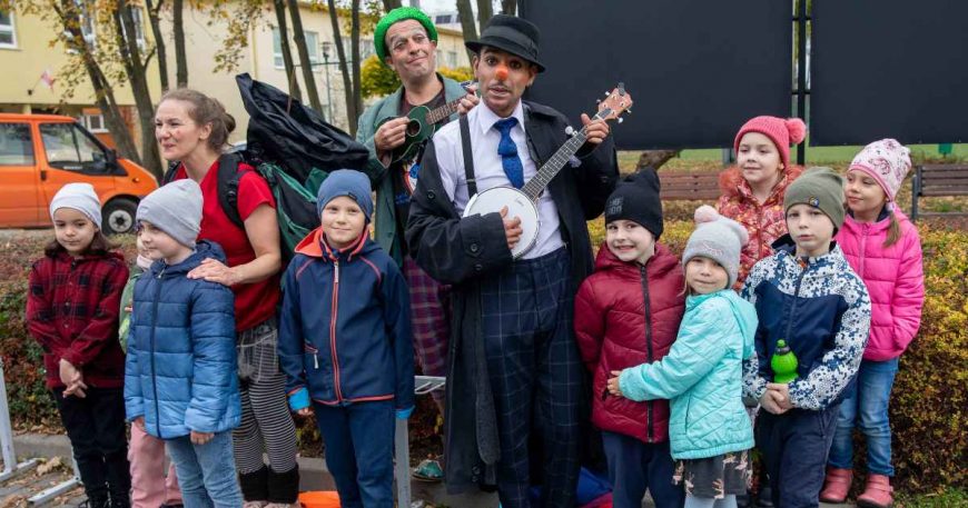 clown with a ukelele with a group of kids