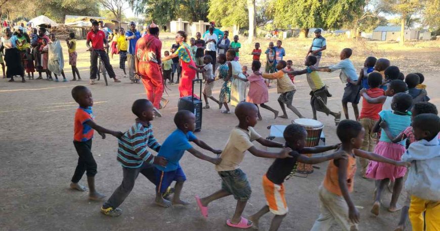 Kids in Zimbabwe form a train behind CWB artist Hannah Gaf