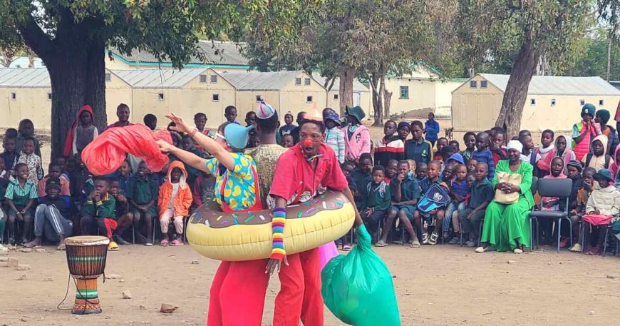 Clowns play in a blow up dounut at a clown show for environmental refugees in Zimbabwe