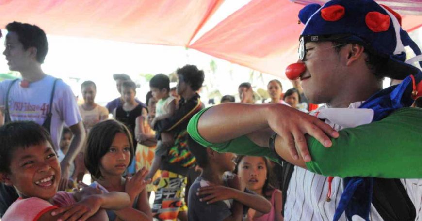 Clowns Without Borders artist interacts with kids after a clown show in The Philippines, 2014.