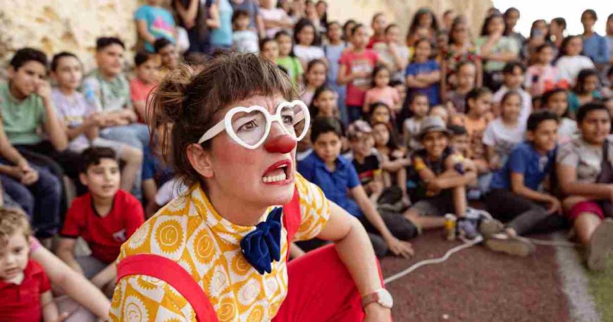 Woman with clown glasses looking off screen