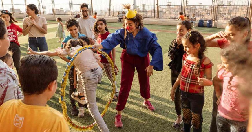 children jumping through hoops at a clown show in Egypt