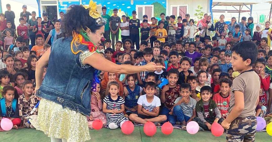 A child on stage with a clown in a show for people who are stateless in Iraqi Kurdistan