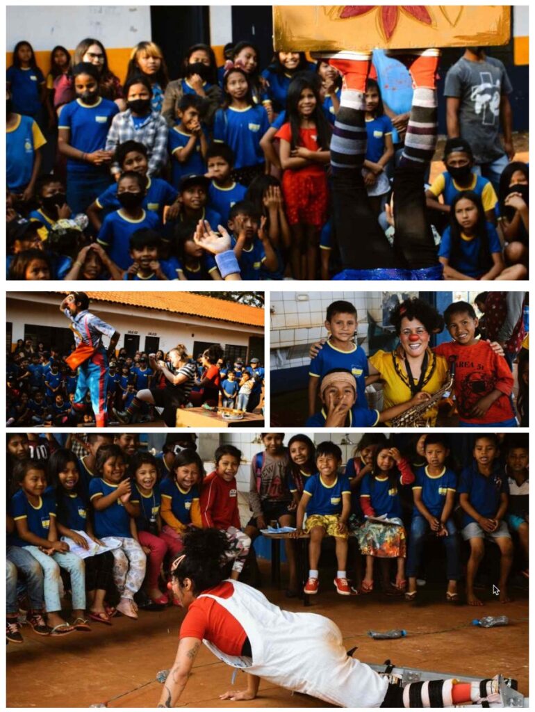 CWB performing artist juggles a table with her feet in front of a croud of kids from the Guarani community