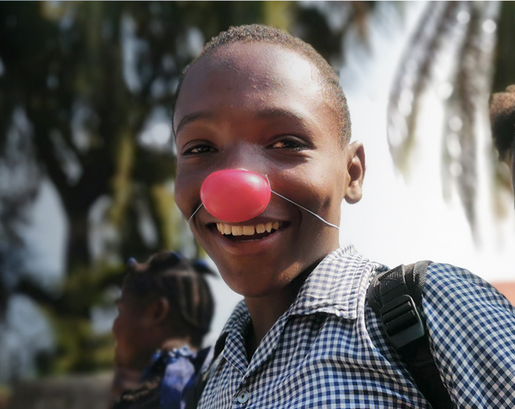 Smiling boy with a red clown nose