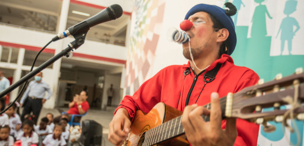 Clown with guitar singing to crowd