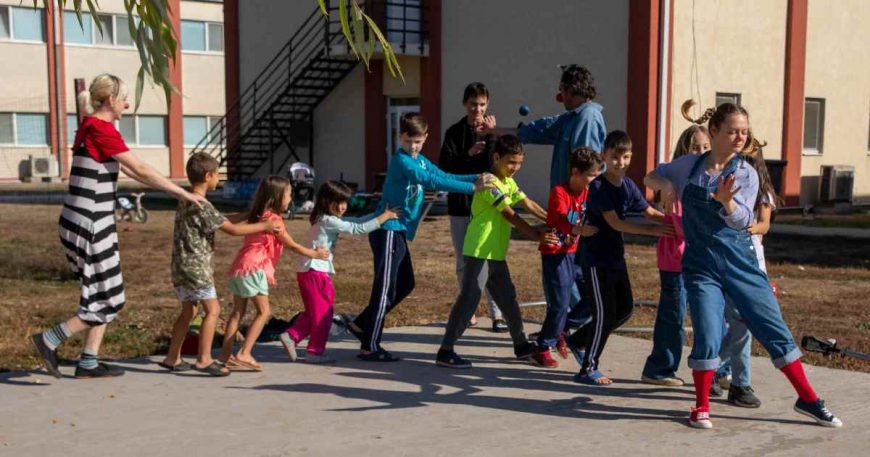 Ukrainian refugee children dance in a congo line with CWB artists in Romania.