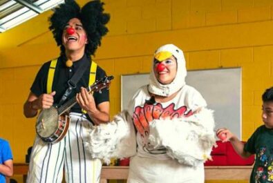 Clown in chicken suit and clown with ukulele