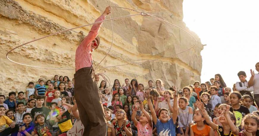 A clown swings a lasso overhead at a clown show in Egypt