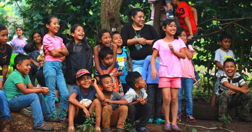 Children and parents laughing at a clown show in Guatemala.