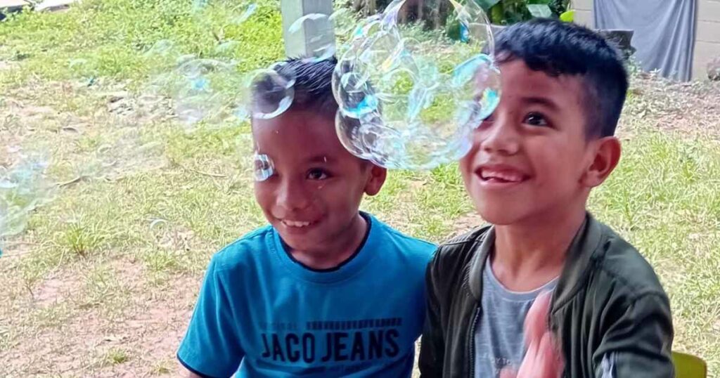 Two young boys delight in bubbles as they participate in a clown show in El Salvador.