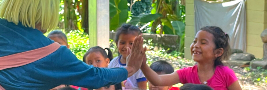 A child high-fives a clown during a tour in El Salvador