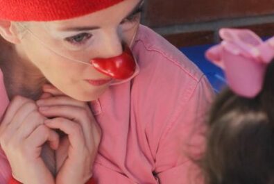 Clown very sweetly listens to a little girl